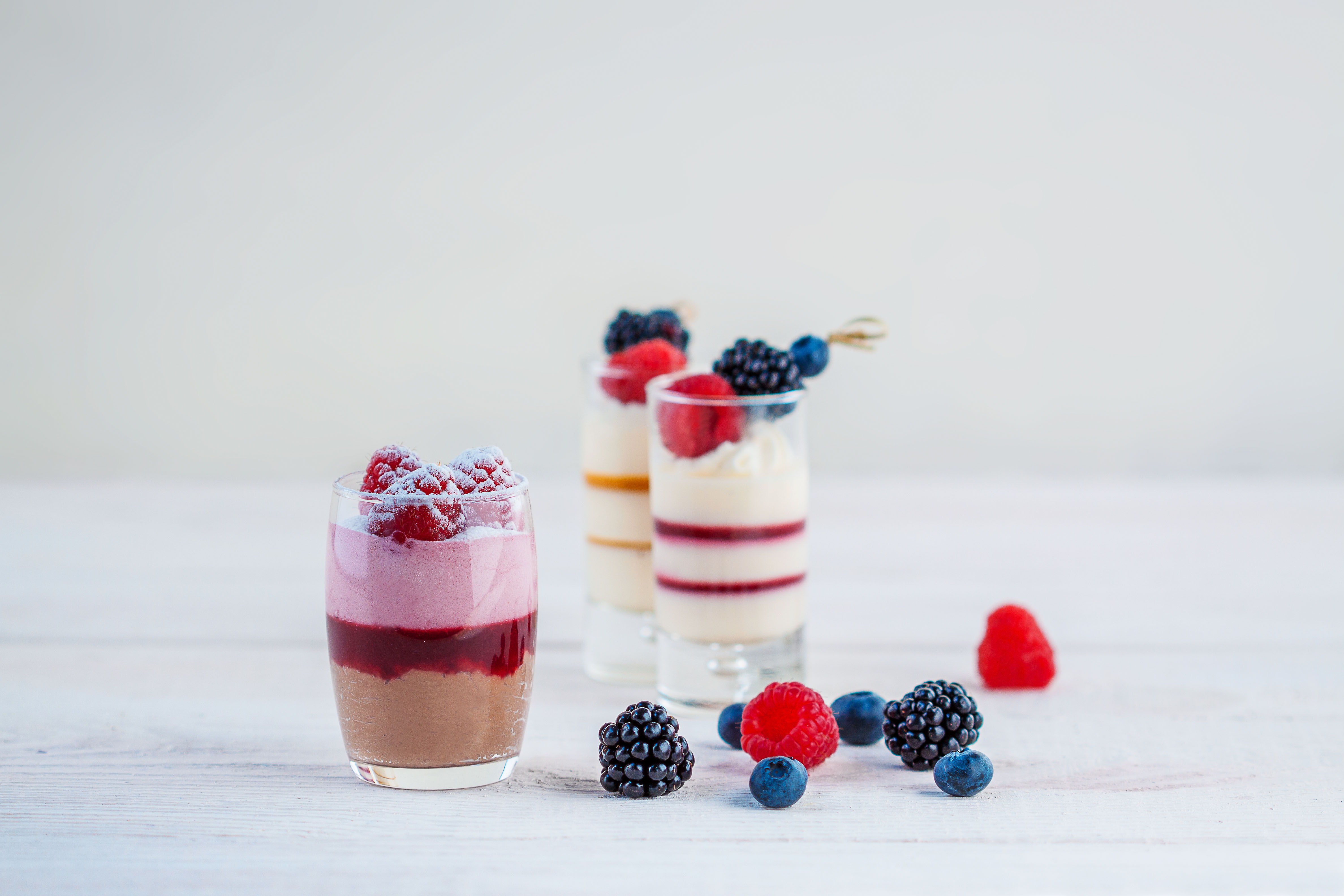 Dessertglaasjes met fruitpuree en rood fruit